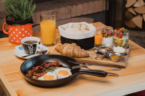 een tafel met een koekenpan met eieren en brood bij Vitranc Apartments in Kranjska Gora