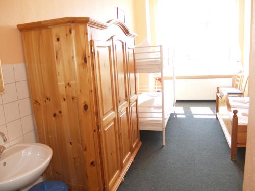 La salle de bains est pourvue d'un lavabo et d'une armoire en bois. dans l'établissement Happy Go Lucky Hotel + Hostel, à Berlin