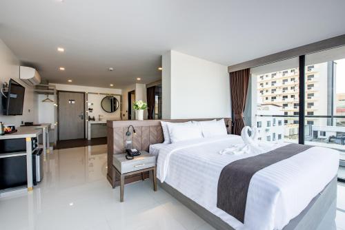 A bed or beds in a room at Blackwoods Hotel Pattaya - SHA Extra Plus