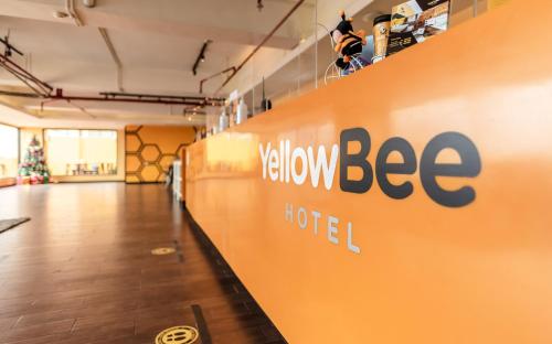 un corridoio con un cartello giallo dell'hotel sulle pareti di Yellow Bee Tangerang a Tangerang