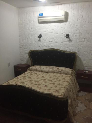 a bed in a bedroom with a white brick wall at Departamento Libertad in San Salvador de Jujuy