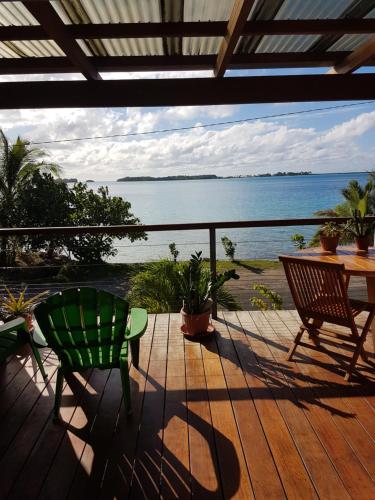 eine Terrasse mit einem Tisch und Stühlen sowie Meerblick in der Unterkunft Studio Moana in Bora Bora