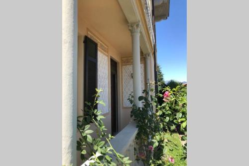 a porch of a house with pink flowers at Villa Peachey, Intero piano con giardino in Stresa