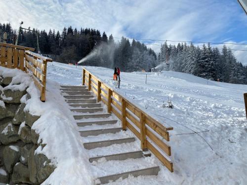 a person walking down a snow covered slope with stairs at Hotel Sonnenalm Stuhleck in Spital am Semmering