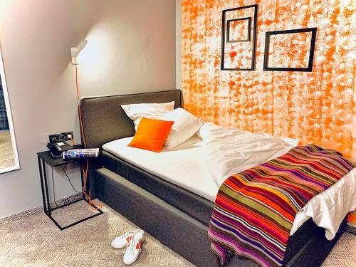 um quarto com uma cama com uma parede laranja em Hotel Maxplatz em Hof