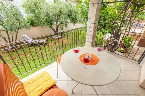 einen Tisch mit zwei Gläsern Wein auf dem Balkon in der Unterkunft Apartments Nono in Poreč