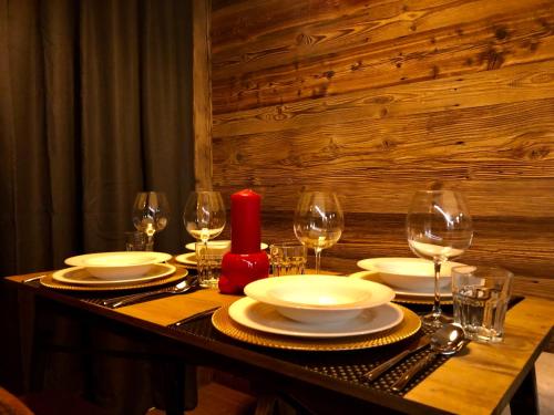 une table avec des assiettes, des verres et une bougie rouge dans l'établissement Central Apart Chalet, à Breuil-Cervinia