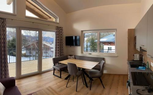 a dining room with a table and chairs and a balcony at Appartements Blumenwiese in Ramsau am Dachstein