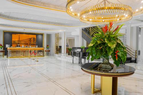 eine Lobby mit einem Klavier und einem großen Kronleuchter in der Unterkunft Hotel Savoy Homann in Bandung