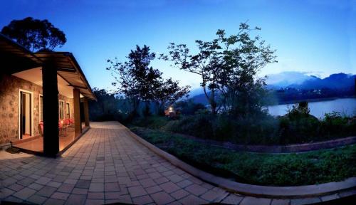 un edificio con passerella accanto a un lago di Ottway Hills Near Mattupetty Dam a Munnar