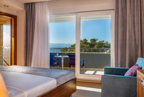 ein Hotelzimmer mit einem Bett und einem Balkon in der Unterkunft Hotel Plaža in Omiš