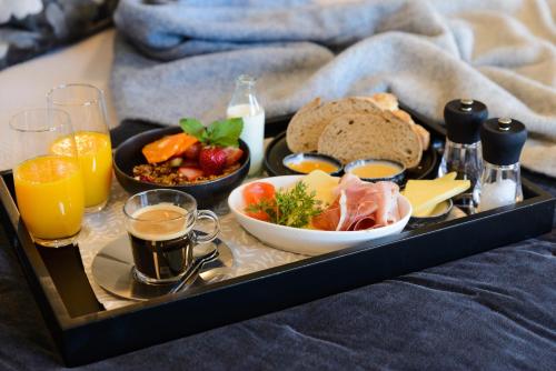 un vassoio di prodotti per la colazione e bevande su un letto di 14th Lane Urban Hotel a Blenheim