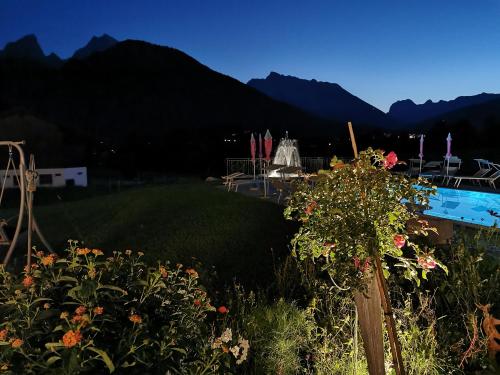 un giardino fiorito e una piscina di Gästehaus Obersulzberglehen a Schönau am Königssee