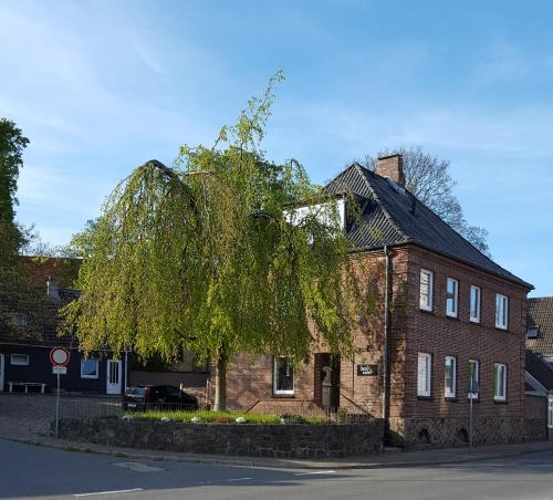 a tree in front of a brick building at Gästehaus bed & kitchen in Schleswig