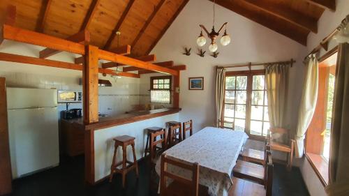 - une cuisine et une salle à manger avec une table et des chaises dans l'établissement Cabañas & Aparts Lancuyen, Villa de Montaña, à Villa La Angostura