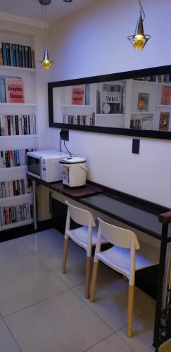 a desk with two chairs in a library with books at Sur Hotel in Montevideo