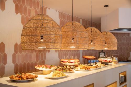 un buffet con muchos platos de comida en una barra en The 15th Boutique Hotel by Bondia Group, en Lloret de Mar