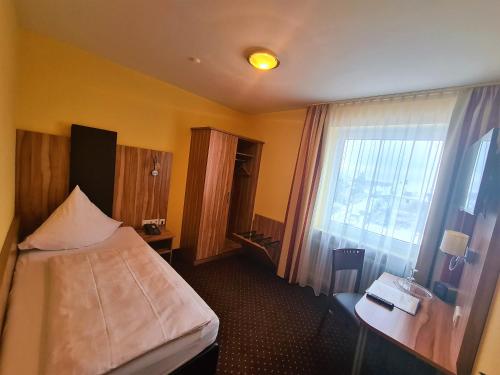 pokój hotelowy z łóżkiem i oknem w obiekcie Hotel Silberhorn w Norymberdze