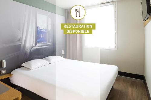 a bedroom with a white bed and a sign that reads restorationbuquerque at B&B HOTEL Montauban in Montauban