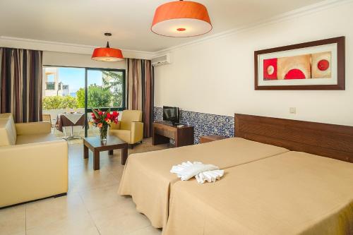 a hotel room with a bed and a living room at Cerro Mar Atlantico & Cerro Mar Garden in Albufeira