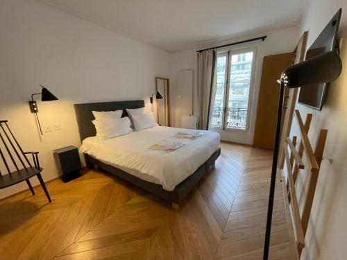 una camera con un letto e una grande finestra di RESIDENCES HARCOURT - Ile Saint Louis - PARIS a Parigi