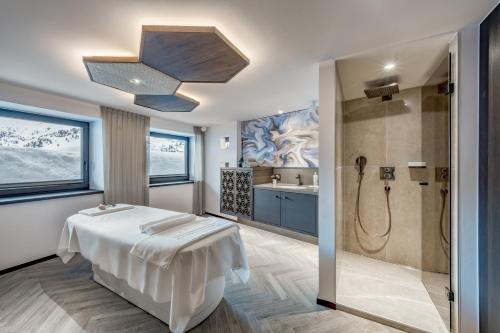 a bathroom with a bed and a shower at Alpen-Wellness Resort Hochfirst in Obergurgl