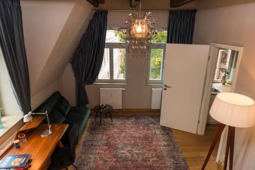 uma sala de estar com um sofá verde e um lustre em Apartmenthaus am Dom "Maisonette" em Zwickau