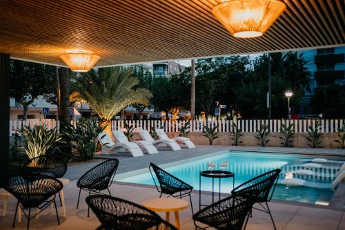 - une piscine avec des chaises et une table dans l'établissement Instants Boutique Hotel - Adults Only, à Cambrils