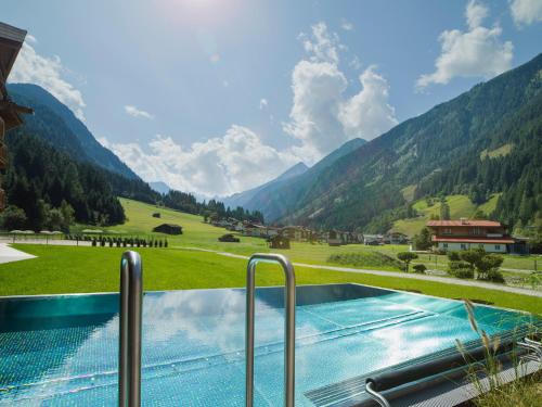 uma piscina com vista para uma montanha em Living & Spa Vitalhotel Edelweiss em Neustift im Stubaital