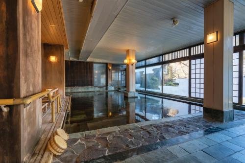 een grote kamer met een zwembad in een gebouw bij Tabist Kinugawa Park Cottage in Nikko