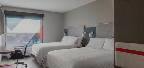 a hotel room with two beds and a window at avid hotels - Prattville - Montgomery North, an IHG Hotel in Prattville