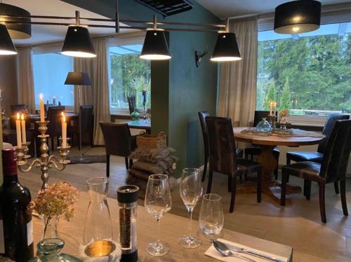 una sala da pranzo con tavolo e bicchieri da vino di Landhotel Flora & Fauna a Winterberg