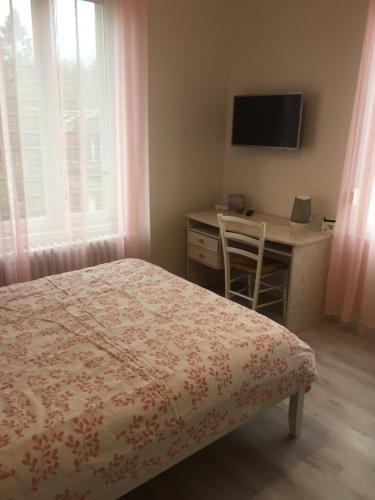 - une chambre avec un lit, un bureau et une télévision dans l'établissement La Vie est Belle, à Abbeville