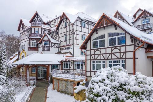 una grande casa con neve per terra di Park Hotel Kur & Spa a Świeradów-Zdrój