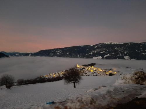 eine Stadt inmitten eines schneebedeckten Berges in der Unterkunft Platiederhof in Lajen