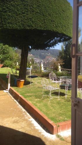 een groep stoelen en tafels op het gras bij Wyoming Heritage in Ooty