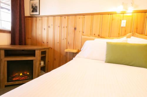 um quarto com uma cama e uma lareira em Gateway Motel em Radium Hot Springs