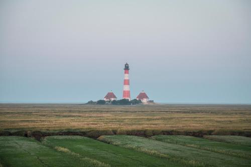 un faro in mezzo a un campo di Kirchspielkrug Landhotel & Restaurant a Westerhever