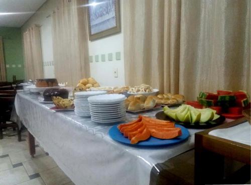 una mesa larga con platos de comida. en Catalao Palace Hotel, en Catalão