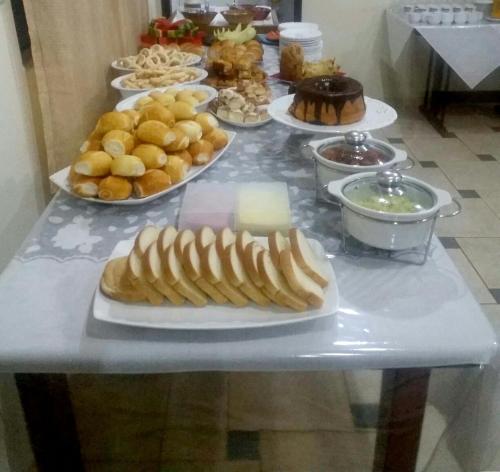 una mesa con muchos platos de comida. en Catalao Palace Hotel, en Catalão