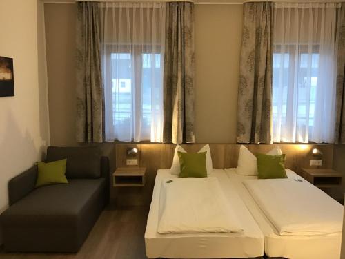 salon z 2 łóżkami i kanapą w obiekcie Gasthof Hotel Esterer w mieście Rosenheim