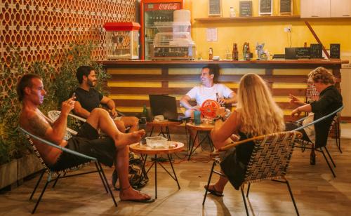 een groep mensen die rond een tafel in een restaurant zitten bij Distrito Hostel in Santa Marta