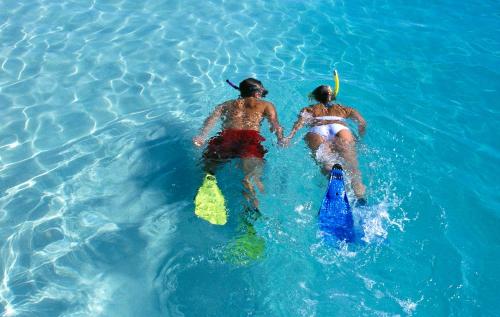 duas pessoas estão brincando na água na água em Windsong on the Reef em Grace Bay