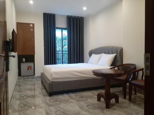 1 dormitorio con cama, mesa y ventana en PEACE HOTEL, en Vung Tau