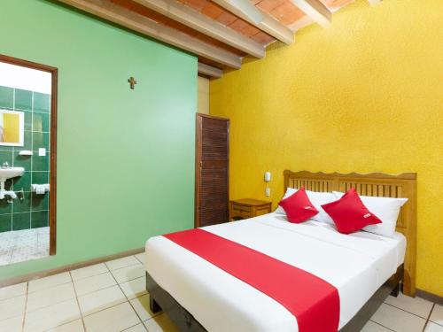 een slaapkamer met een groot bed met rode kussens bij Hotel Posada San Rafael in Oaxaca City