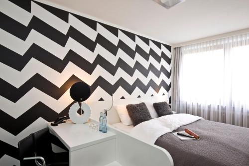 ein Schlafzimmer mit einer schwarz-weißen Chevron-Wand in der Unterkunft Hotel & Restaurant Rosenthal Casino in Selb