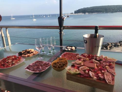 a table with plates of food and glasses of wine at Appartement cosy les pieds dans l’eau, vue mer exceptionnelle in Crozon