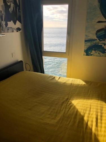 a bedroom with a bed and a window at Appartement cosy les pieds dans l’eau, vue mer exceptionnelle in Crozon