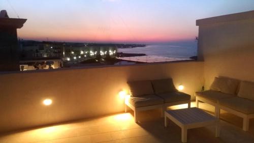 Habitación con sofá y ventana con vistas. en FONTEblu B&B, en Polignano a Mare