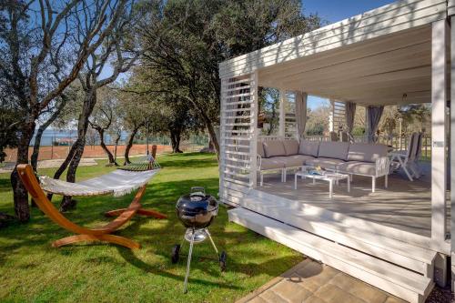 uma pérgola de madeira com um sofá e um grelhador em Maistra Camping Amarin Mobile homes em Rovinj